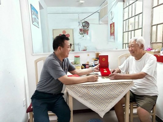 郑州市科技进修学院88岁老党员接收“光荣在党50年”纪念章